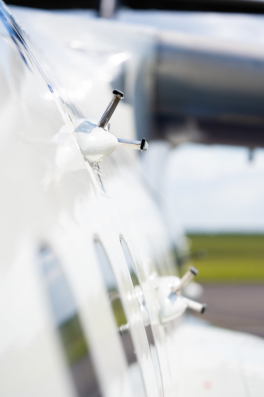 Silver probes mounted on side of blue and white research aircraft.